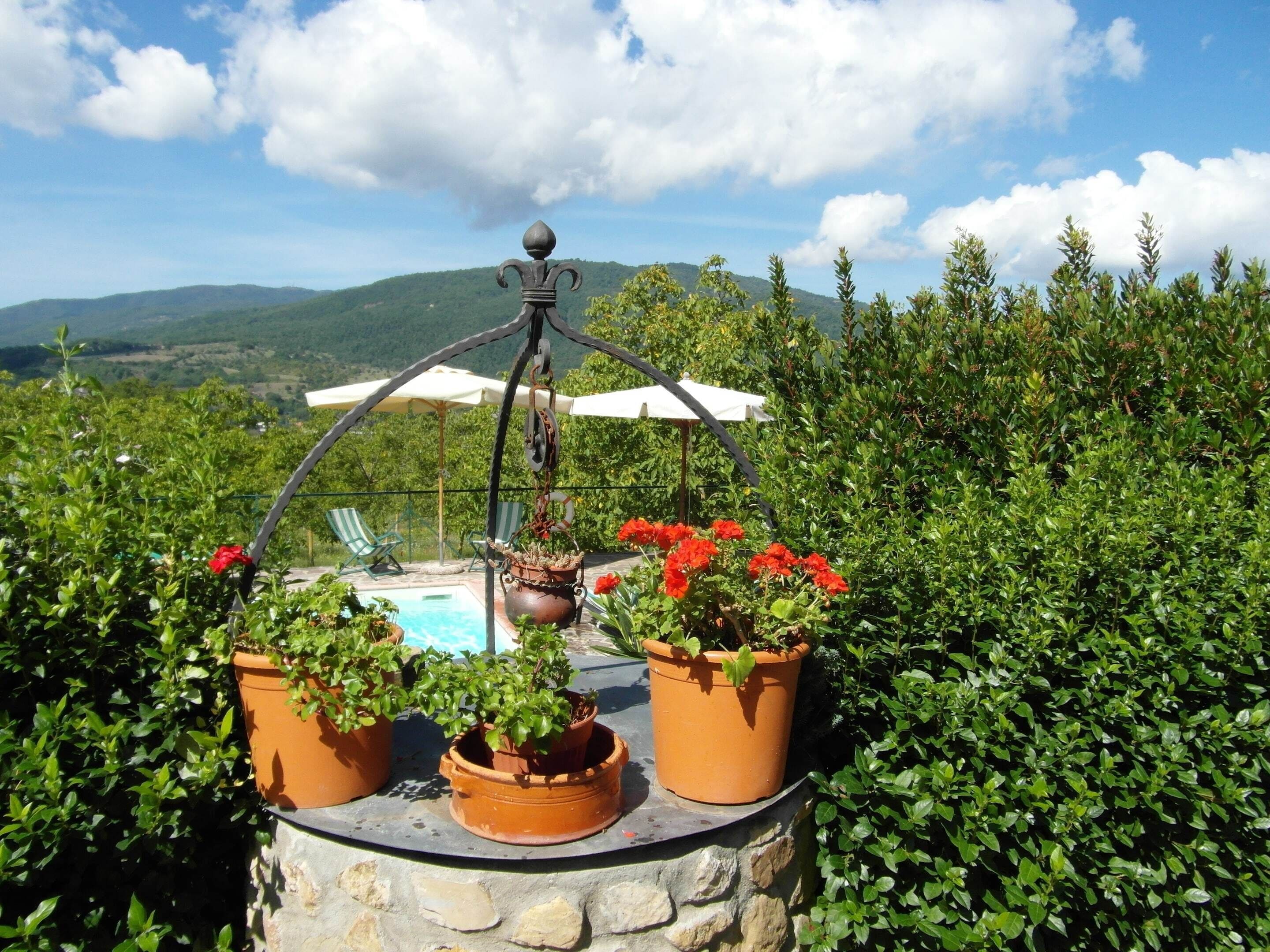 A stone table with potted plants and a hanging metal ornament.