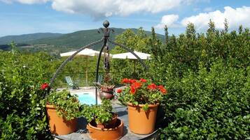 A stone table with potted plants and a hanging metal ornament.