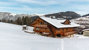 A wooden chalet with a balcony, set against a snowy mountain backdrop. - Mansion in Eben Near Ski Salzburger Sportwelt (Eben im Pongau)