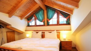 A bedroom with a wooden bed, a window with curtains, a nightstand, and a lamp. - Mansion in Eben Near Ski Salzburger Sportwelt (Eben im Pongau)
