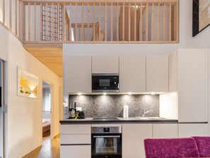 Enjoy cooking in this well-lit kitchen with a stainless steel range hood and oven.