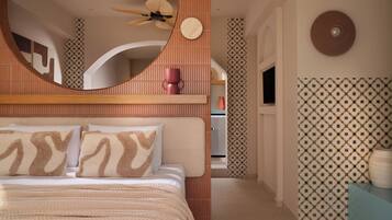 Un dormitorio con cama, almohadas, ventilador de techo, televisión y paredes con diseño.