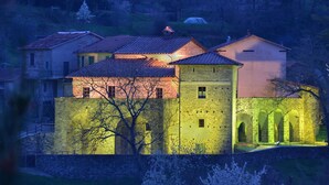 Un edificio histórico con fachada de piedra, múltiples ventanas y un patio central con arcos.