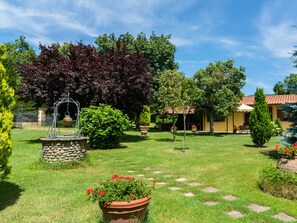 A well-maintained garden with a variety of plants and a stone fountain.