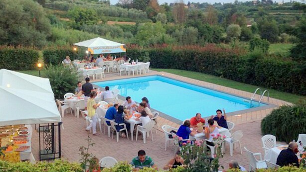 An outdoor pool area with dining tables and chairs, surrounded by greenery and a clear blue sky. - Sunlit Home With Pool (Fucecchio)