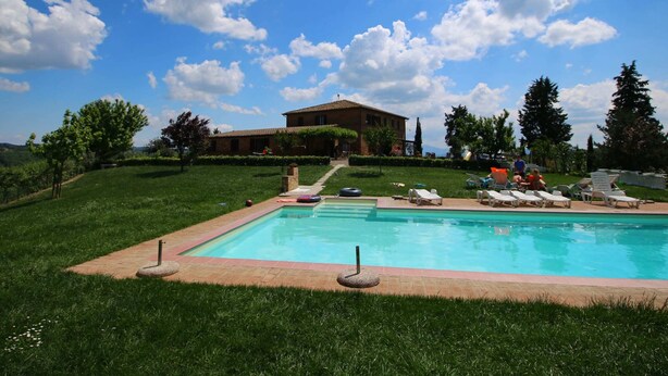 A swimming pool with lounge chairs and a building in the background. - 360 Degree View of the Tuscan (Buonconvento)