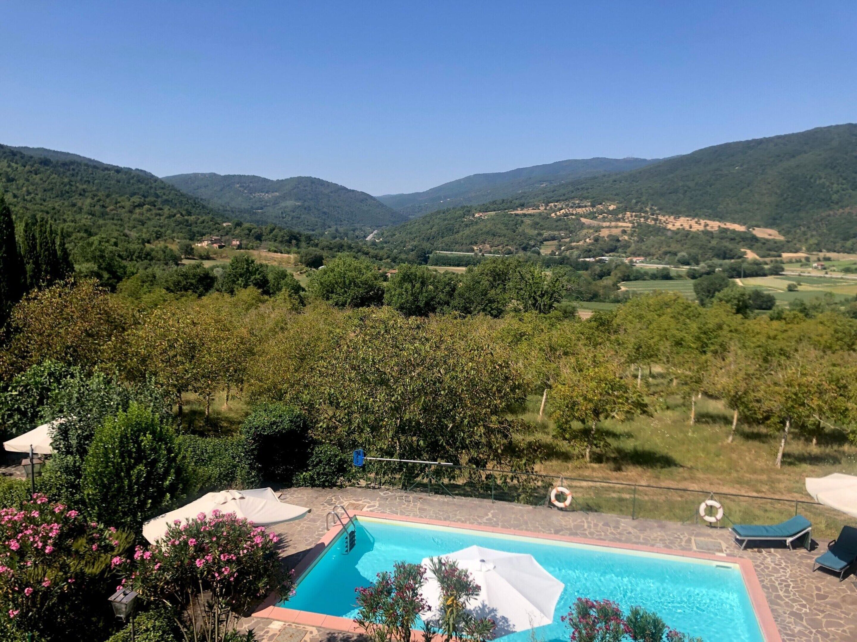 A pool with a view of a valley and hills.