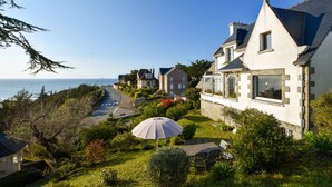 Una zona residencial costera con casas, un camino y vista al mar.