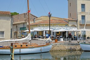 En restaurant ved vandet med udendørs servering, både i havnen og traditionel arkitektur.