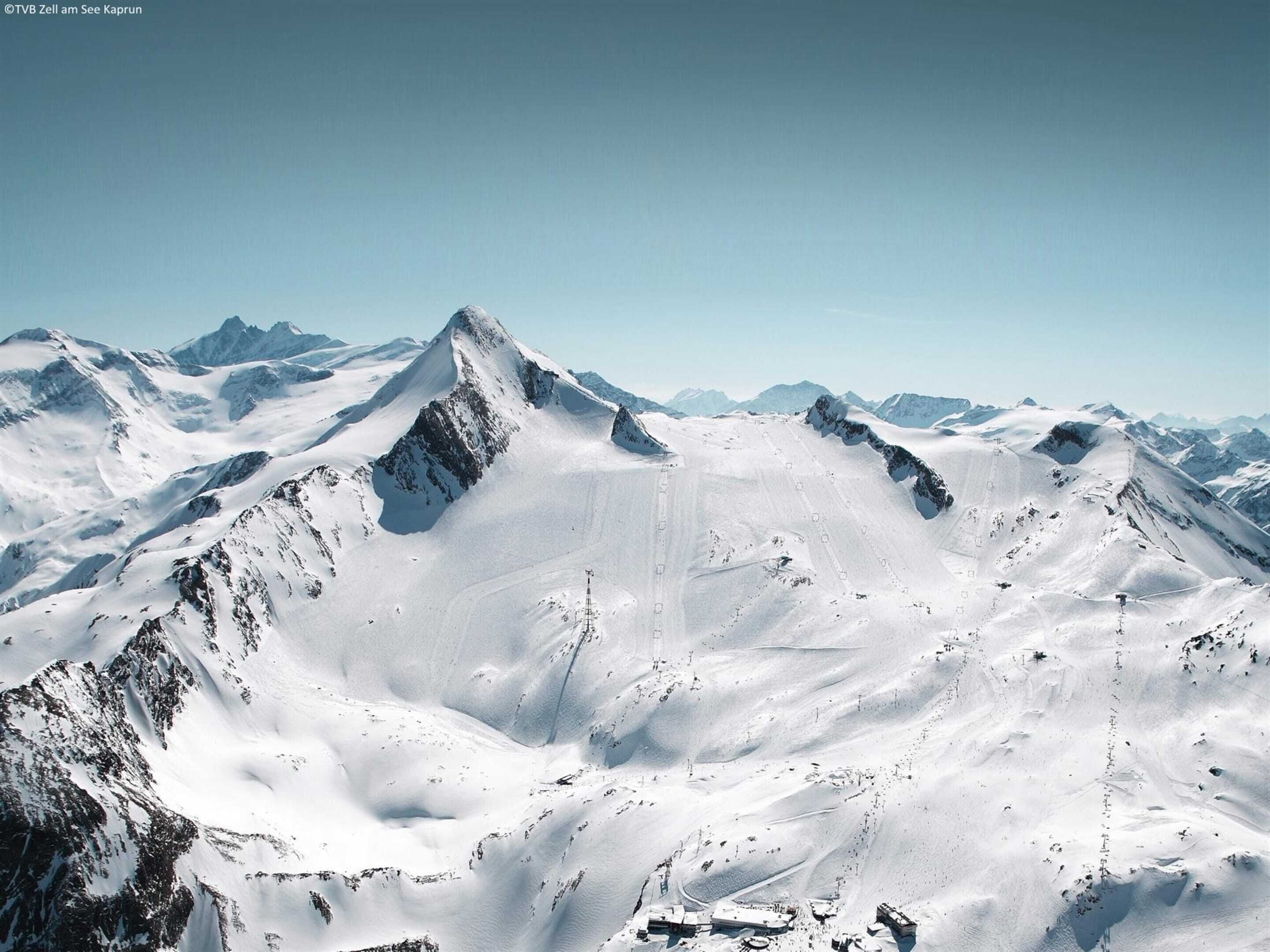 Un paysage montagneux enneigé sous un ciel dégagé.