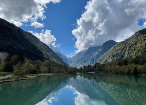 A serene lake surrounded by mountains with clear reflections.