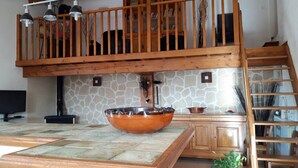 A kitchen with a stone backsplash, wooden cabinets, a large bowl on the counter, and a wooden staircase. - Relaxing Retreat in Saint-pons (Saint-Pons)