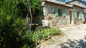 A stone building with a tiled roof, green shutters, and a gravel path. - Relaxing Retreat in Saint-pons (Saint-Pons)