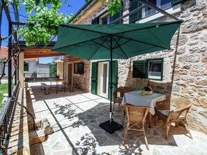 Relax in style with a table set amidst lush surroundings and a shaded patio.