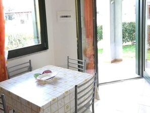 A dining area with a table, chairs, and a window. - Residence with Swimming Pool in Green Countryside near Thermal Baths (Santa Maria Coghinas)