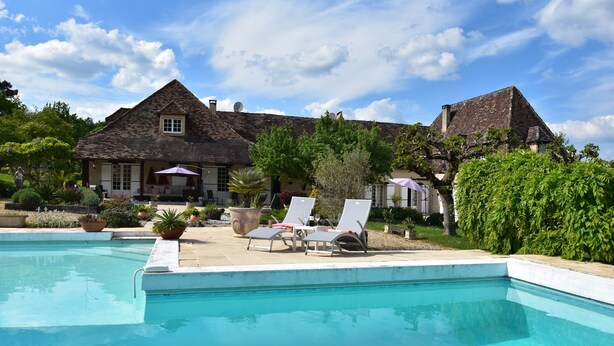 A swimming pool with lounge chairs, a house with a pitched roof, and a clear sky. - Luxury Villa in Dordogne With Pool & Privacy (Port-Sainte-Foy-et-Ponchapt)