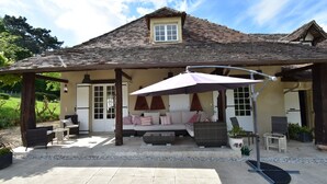 A covered outdoor seating area with a sofa, chairs, and a table. - Luxury Villa in Dordogne With Pool & Privacy (Port-Sainte-Foy-et-Ponchapt)