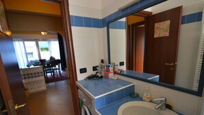 Un bagno con lavatrice, lavandino e specchio.