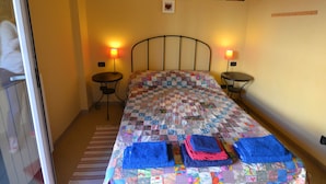Una camera da letto accogliente e confortevole, con un letto, due comodini e una finestra.