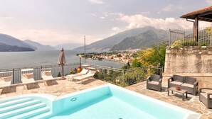 A pool area with lounge chairs and a view of a lake and mountains. - Belvilla by OYO Romantica (Gravedona)