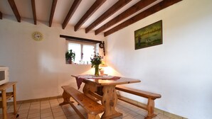 A wooden table with benches, a clock, a window with plants, and a painting on the wall. - Normandy Bakery Retreat (Torigny-les-Villes)
