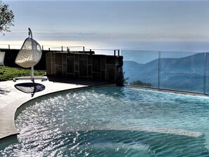 A modern infinity pool with a clear view of the ocean and mountains in the background. - Air-conditioned With a Pool,spa and Fitness Centre (Magliolo)