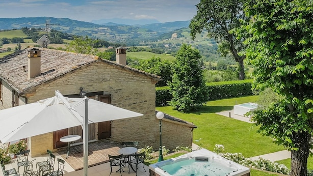 A stone house with a patio, outdoor seating, and a hot tub. - Scenic Villa With Heated Pool (Sant'Ippolito)