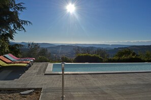 A pool with a view of distant mountains, lounge chairs, and a clear sky. - Tranquil Vineyard Villa, Berlou (Berlou)