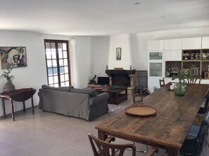 A living room with a sofa, a wooden dining table, and a fireplace. - Tranquil Vineyard Villa, Berlou (Berlou)