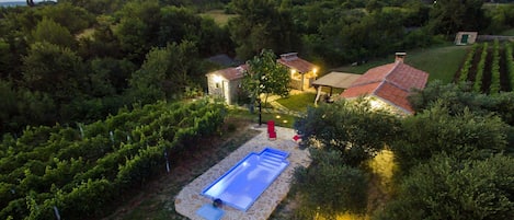 Ein Weinberg mit Schwimmbad und einem kleinen Haus mit rotem Dach.