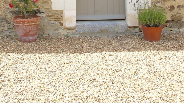 A stone building with a wooden door, a small window, and two potted plants. - Holiday Home in Angers With Private Garden (Bierné-les-Villages)