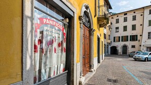A bakery with a sign reading "PANIFICIO PASTA & SACCETTO" on a yellow building.