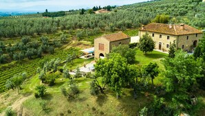 A stone building with a tiled roof surrounded by olive groves and a grassy area. - Farmhouse in Vinci With Pool and Tuscan Views (Vinci)