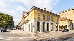 A yellow building with a classical facade, a street in front, and a clear sky. - Stay in Verbania Pallanza (Verbania)