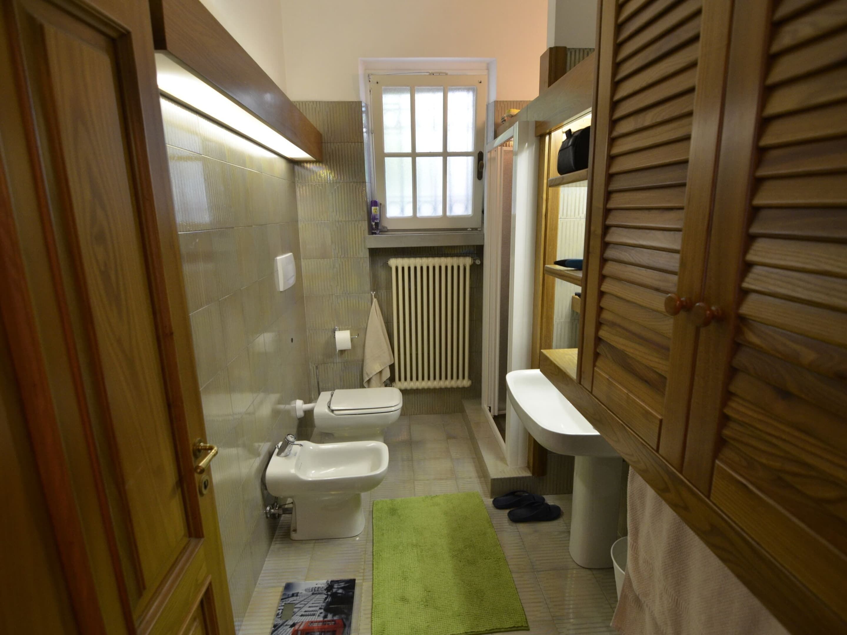 A compact bathroom with a toilet, bidet, and sink.