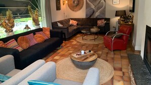 A modern living room with a sectional sofa, a red armchair, a coffee table, and a fireplace.