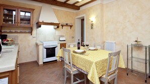 Una cocina compacta con estufa, horno y una mesa de comedor para dos personas.