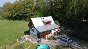 A two-story house with a swimming pool, a covered patio, and a driveway. - House With the Pool and Fenced Garden, Great View at Trosky Castle (Ktová)
