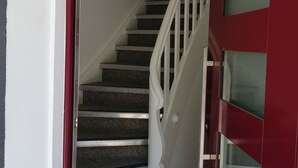 A staircase with white railings leading to a landing. - Comfy Apartment in Oppenau near Black Forest National Park (Oppenau)