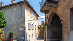 A narrow street with buildings on either side, featuring a cobblestone path and a small bridge. - Appartamento in Centro Storico a Cannero Riviera (Cannero Riviera)
