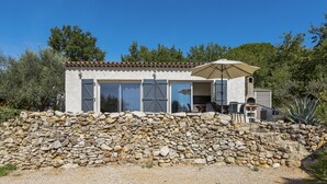 A stone house with a patio, large windows, and a stone wall. - Holiday Home in Brignoles With Private Pool (Brignoles)