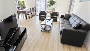 A modern living room with a sofa, chairs, a coffee table, and a TV. - Holiday Home in Brignoles With Private Pool (Brignoles)