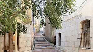 A narrow alleyway with a brick pathway, trees, and buildings with stone walls and windows. - Holiday Home in Brignoles With Private Pool (Brignoles)