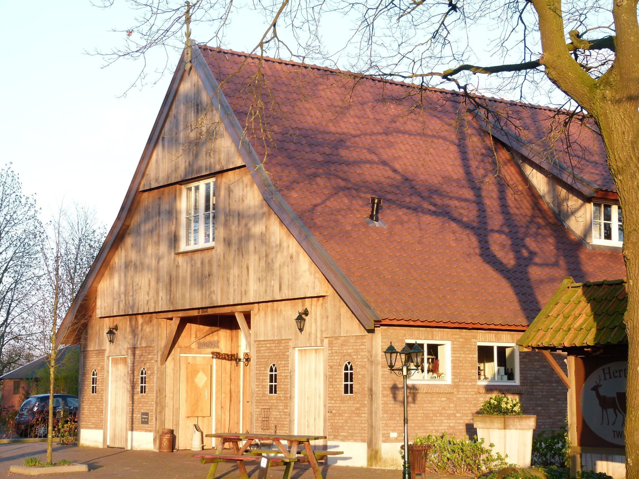 A wooden building with a sloped roof, a wooden door, and a bench outside.
