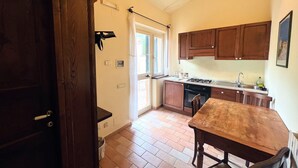 A compact kitchen with wooden cabinets, a gas stove, and a sink. - Farmhouse in Giano Dell'umbria with Hot Tub, Swimming Pool (Giano dell'Umbria)