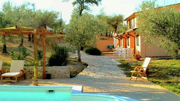 A swimming pool with lounge chairs, a pergola, and a building with outdoor seating. - Farmhouse in Giano Dell'umbria with Hot Tub, Swimming Pool (Giano dell'Umbria)