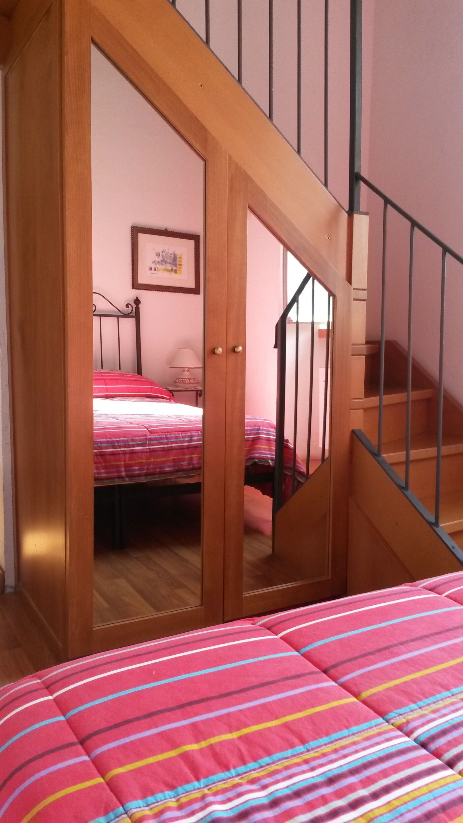 Una camera da letto con un letto, un armadio in legno e una scala.