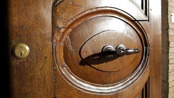 Una puerta de madera con una cerradura de bronce y un ojo de cerradura.
