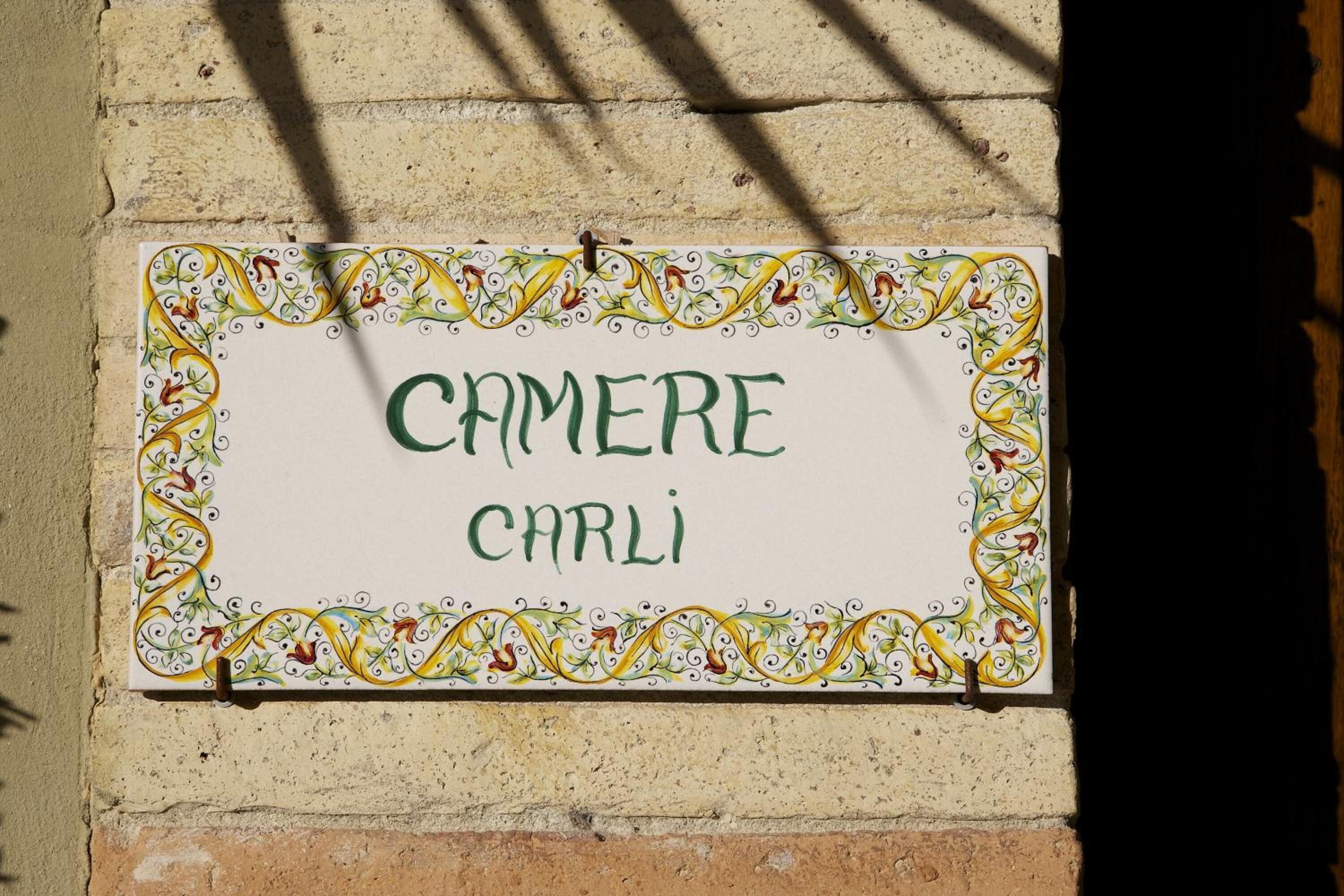 A sign with the text "CAMERE CARLI" on a wall.