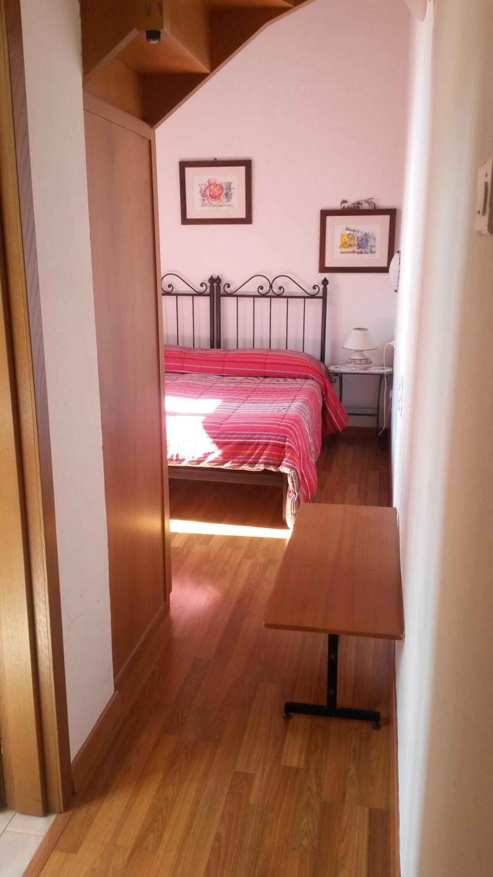 Une chambre à coucher avec un lit, une table de chevet et un bureau.